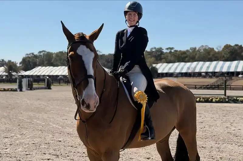 Young rider smiling in show attire